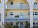 Three story building featuring neutral colors, white railings, archways, and lush landscaping at 2259 Costa Rican Dr # 23, Clearwater, FL 33763