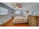 Cozy bedroom featuring wood floors, a ceiling fan, and a large wood dresser at 2269 Beverly Ln, Clearwater, FL 33764