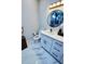 Powder room featuring white vanity, framed mirror, and marble look floors, with a modern design at 2925 W Dewey St, Tampa, FL 33607