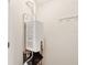 Tankless water heater with modern fittings and fixtures in white room with hardware at 3005 Bayshore Pointe Dr, Tampa, FL 33611