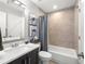 Cozy bathroom showcasing a marble countertop sink, neutral tile, and matching shower curtain at 301 Madeira Cir, Tierra Verde, FL 33715