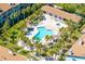 Aerial view of a resort-style community pool surrounded by palm trees and lounge chairs at 301 Madeira Cir, Tierra Verde, FL 33715