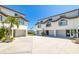 Three-story townhomes featuring private garages, manicured landscaping, arched windows, and waterfront views at 301 Madeira Cir, Tierra Verde, FL 33715
