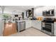 Bright kitchen featuring white cabinets, stainless steel appliances, and open view to the living room at 301 Madeira Cir, Tierra Verde, FL 33715
