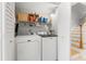 Functional laundry room with white washer and dryer, shelving and storage solutions at 301 Madeira Cir, Tierra Verde, FL 33715