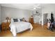 Bright bedroom with wood floors, a white ceiling fan, and a sliding barn door to the closet at 301 Madeira Cir, Tierra Verde, FL 33715