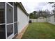 Spacious backyard with lush green grass, screen porch, and a white vinyl fence at 30829 Iverson Dr, Wesley Chapel, FL 33543