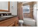 Cozy bathroom with tiled walls, a shower-tub combo, and a wooden vanity with a granite countertop at 30829 Iverson Dr, Wesley Chapel, FL 33543