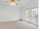 Bedroom with tile floors, neutral walls, ceiling fan, and French door access to backyard at 30829 Iverson Dr, Wesley Chapel, FL 33543