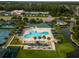 Aerial view of the community pool and tennis courts with green surroundings at 30829 Iverson Dr, Wesley Chapel, FL 33543