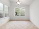 Bright dining area features windows with backyard views, tile floors, and modern chandelier at 30829 Iverson Dr, Wesley Chapel, FL 33543