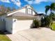 Home featuring a two-car garage, brick-paved driveway and tidy front lawn at 30829 Iverson Dr, Wesley Chapel, FL 33543