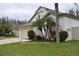 Well-maintained home with a two-car garage, lush lawn, and tropical landscaping creating inviting curb appeal at 30829 Iverson Dr, Wesley Chapel, FL 33543