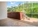 Covered hot tub in screened in patio with tile floor and view of trees at 30829 Iverson Dr, Wesley Chapel, FL 33543