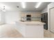 Bright kitchen features an island with sink, ample cabinet space, and modern stainless steel appliances at 30829 Iverson Dr, Wesley Chapel, FL 33543