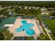 Aerial view of clover-shaped pool with lounge chairs and lush landscaping for a resort-style experience at 30829 Iverson Dr, Wesley Chapel, FL 33543