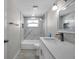 Well-lit bathroom with marble-tiled shower, modern vanity, and stylish fixtures at 5213 Skyland Dr, Holiday, FL 34690