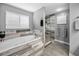 Modern bathroom featuring a soaking tub with wood-look accents and a glass-enclosed shower at 5807 Cay Cove Ct, Tampa, FL 33615