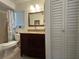 Bathroom featuring vanity with granite top, framed mirror, and toilet inside shower/tub area, with a closet door nearby at 601 N Hercules Ave # 403, Clearwater, FL 33765