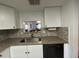 Bright kitchen showcases white cabinets, granite countertops, and a convenient pass-through window to another room at 601 N Hercules Ave # 403, Clearwater, FL 33765