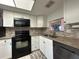 Modern kitchen features white cabinetry, granite countertops, and stainless steel appliances for style and functionality at 601 N Hercules Ave # 403, Clearwater, FL 33765