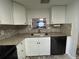 A charming kitchen with a stainless steel sink, granite countertops, and a pass-through window to the living area at 601 N Hercules Ave # 403, Clearwater, FL 33765
