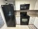 Efficient kitchen layout with modern black appliances, granite countertops, and white cabinets for a clean, contemporary look at 601 N Hercules Ave # 403, Clearwater, FL 33765
