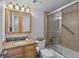 Bathroom featuring tub, tile surround, glass doors, grab bar, wooden vanity with mirror, and toilet at 6158 Palma Del Mar S Blvd # 406, St Petersburg, FL 33715