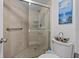 Bathroom shower featuring tile surround, glass doors, shower head, and a grab bar for accessibility and safety at 6158 Palma Del Mar S Blvd # 406, St Petersburg, FL 33715