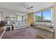 Bright living room featuring a comfortable sofa, large windows, and mirrored wall at 6158 Palma Del Mar S Blvd # 406, St Petersburg, FL 33715