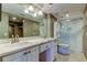 Modern bathroom with double vanity, stone countertops, and a walk-in shower with glass enclosure at 6265 Sun Blvd # 806, St Petersburg, FL 33715