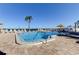 Community pool with lounge chairs, palm tree, and bay view on a sunny day at 6265 Sun Blvd # 806, St Petersburg, FL 33715