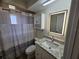 Updated bathroom with new vanity, granite countertop, modern lighting, and decorative shower curtain at 6533 Brentwood Dr, Zephyrhills, FL 33542