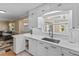 Bright kitchen features white cabinetry, stainless steel sink, and quartz countertops at 6888 124Th Ave, Largo, FL 33773