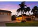 Charming backyard featuring palm trees and string lights at dusk, creating a cozy atmosphere at 702 Pass A Grille Way, St Pete Beach, FL 33706