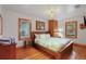 Charming bedroom featuring wood floors, panelled walls, a brick pillar, two windows, and a comfortably decorated queen bed at 702 Pass A Grille Way, St Pete Beach, FL 33706