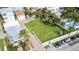 A vacant lot with brick driveway, tropical landscaping, bordered by white fencing and neighborhood views at 702 Pass A Grille Way, St Pete Beach, FL 33706