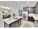 Modern kitchen with stainless steel appliances, dark cabinetry, and island open to the dining area at 7211 Meeting House Ln, Apollo Beach, FL 33572