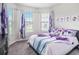 Inviting bedroom with large windows, floral curtains, and a comfortable bed, providing a serene retreat at 7494 Pool Compass Loop, Wesley Chapel, FL 33545