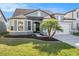 Charming home with a well-manicured lawn, mulch, and a paved driveway leading to an attached garage at 7494 Pool Compass Loop, Wesley Chapel, FL 33545