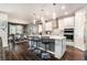 Open-concept kitchen with an island, breakfast bar, modern appliances, and pendant lights is perfect for entertaining at 7494 Pool Compass Loop, Wesley Chapel, FL 33545