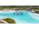 Scenic view of a lagoon featuring an inflatable water park, a long blue water slide, and a pristine sandy beach at 7494 Pool Compass Loop, Wesley Chapel, FL 33545