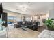 Open concept living room with a modern kitchen, large sectional sofa, sliding glass doors, and plenty of natural light at 7494 Pool Compass Loop, Wesley Chapel, FL 33545