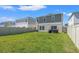 Well maintained backyard with a white fence, lush lawn, and barbecue at 7580 Freesia Trce, Wesley Chapel, FL 33545