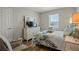 Comfortable bedroom with a dresser with a TV and a chair with natural light at 7580 Freesia Trce, Wesley Chapel, FL 33545