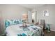 Cozy bedroom featuring a bed with leaf-patterned sheets, and a flamingo art piece on the wall at 7580 Freesia Trce, Wesley Chapel, FL 33545