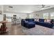 Open-concept living room with a large blue sectional sofa and adjacent kitchen at 7580 Freesia Trce, Wesley Chapel, FL 33545