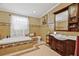 Bathroom with ornate tile work, a soaking tub, and a dark wood vanity at 762 Marjon Ave, Dunedin, FL 34698