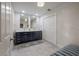 Bathroom with double vanity, modern tile floors, and a separate toilet area at 7922 Spring Valley Dr, Tampa, FL 33615