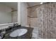 Stylish bathroom featuring granite countertops and a shower/tub with patterned curtain at 7922 Spring Valley Dr, Tampa, FL 33615